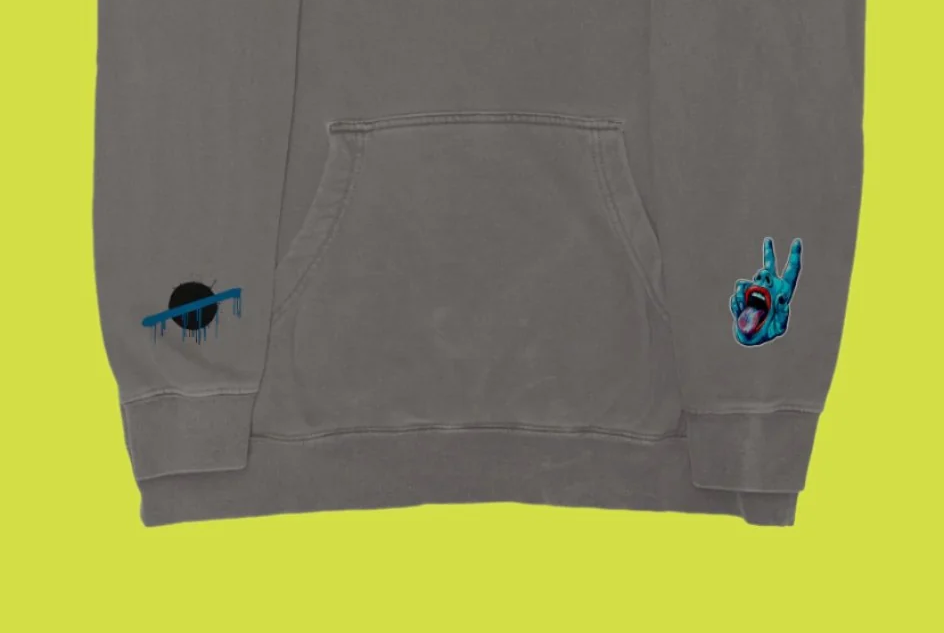 Carve Collective OW Splatter pigment cement hoodie, front pocket and sleeve artwork detail.